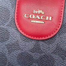 Load image into Gallery viewer, Close-up of a red Coach wallet on a textured gray background