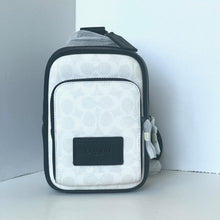 Load image into Gallery viewer, White and black crossbody bag with a visible brand logo on a light gray background