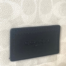Load image into Gallery viewer, Black leather cardholder with 'Coach' branding on a textured white background