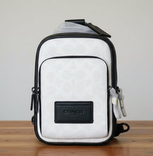 Load image into Gallery viewer, White and black bag with a visible brand logo on a white background