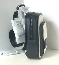 Load image into Gallery viewer, Black and white backpack with tags on a white background