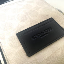 Load image into Gallery viewer, Black Coach logo on a beige leather product