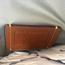 Load image into Gallery viewer, Coach wallet with brand name on a textured gray background