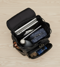 Load image into Gallery viewer, Black backpack with items inside on a white background