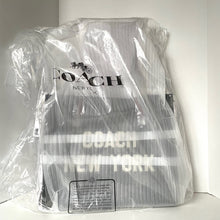 Load image into Gallery viewer, Coach backpack wrapped in clear plastic on a white background