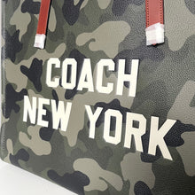Load image into Gallery viewer, Camouflage-patterned bag with 'Coach New York' text on a white background