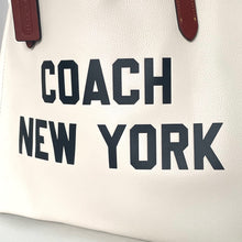 Load image into Gallery viewer, White handbag with 'Coach New York' text on a light gray background