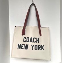 Load image into Gallery viewer, Beige tote bag with 'Coach New York' text and brown handles on a white background