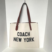 Load image into Gallery viewer, Beige tote bag with 'Coach New York' text and brown handles on a white background