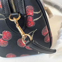 Load image into Gallery viewer, Black handbag with red floral pattern and gold clasp on a white surface