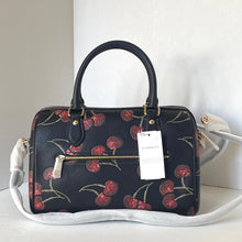 Load image into Gallery viewer, Handbag with cherry pattern and Coach tag on a white surface