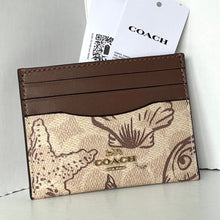Load image into Gallery viewer, Coach cardholder with brown leather strip and logo on a light gray background