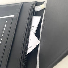 Load image into Gallery viewer, Black leather wallet with a card inside, on a light gray background