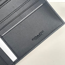 Load image into Gallery viewer, Close-up of a gray Coach wallet on a light beige background