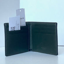Load image into Gallery viewer, Green leather wallet with Coach branding on a light blue background
