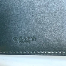Load image into Gallery viewer, Close-up of a green leather Coach wallet with visible stitching.