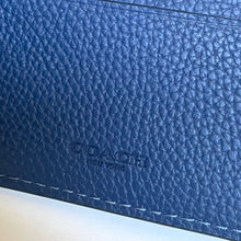 Load image into Gallery viewer, Close-up of a blue leather wallet with &#39;Coach&#39; branding.