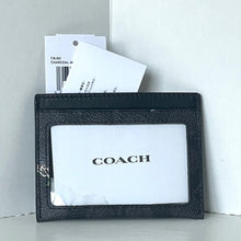 Load image into Gallery viewer, Black Coach wallet with a white card inside on a light gray background