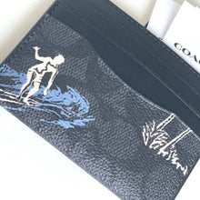 Load image into Gallery viewer, Cardholder with a design of a person surfing on a wave, featuring the brand &#39;Coach&#39;.