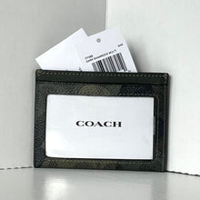 Load image into Gallery viewer, Black Coach cardholder with a white card inside on a light gray background