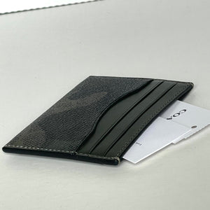 Black leather cardholder with a card inside on a light gray background