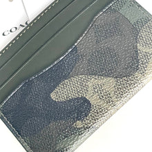 Load image into Gallery viewer, Camouflage-patterned cardholder with &#39;Coach&#39; branding in the background