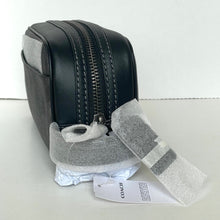 Load image into Gallery viewer, Black leather bag with gray interior on a white surface, featuring a Coach tag.