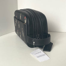 Load image into Gallery viewer, Black leather bag with a Coach tag on a white surface