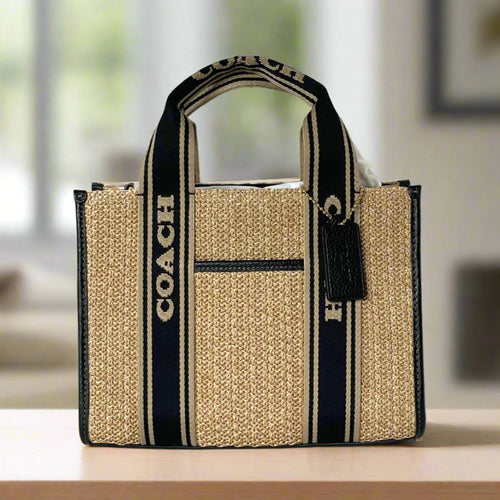 Coach tote bag with black and beige stripes on a white background