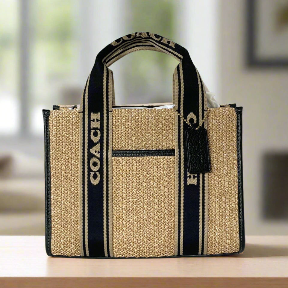 Coach tote bag with black and beige stripes on a white background