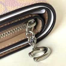 Load image into Gallery viewer, Close-up of a wallet with a metal charm on a light background