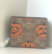 Load image into Gallery viewer, Coach wallet with Halloween pumpkin design on a white surface
