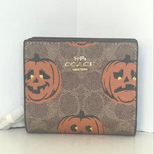 Load image into Gallery viewer, Coach wallet with pumpkin design on a white background