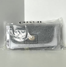 Load image into Gallery viewer, Coach clutch in clear packaging on a gray background