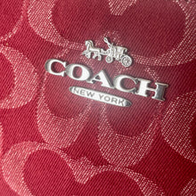 Load image into Gallery viewer, Coach logo on a red fabric background