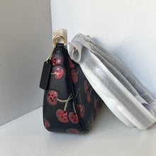 Load image into Gallery viewer, Black handbag with floral pattern and white pouch on a light gray background