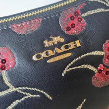 Load image into Gallery viewer, Coach wallet with floral design and gold logo on a black background