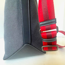 Load image into Gallery viewer, Gray bag with a red and black striped strap on a light background
