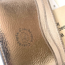 Load image into Gallery viewer, Close-up of Coachtopia logo on a textured surface