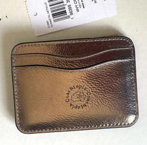 Coach metallic leather card case with a tag on a white background