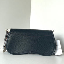 Load image into Gallery viewer, Black leather handbag with a visible brand tag on a light gray background
