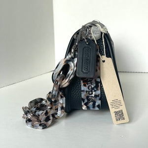 Coach handbag with chain detail and visible tag on a white background