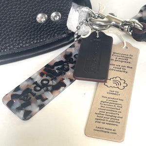 Coachtopia keychain with digital passport and tag on a white background