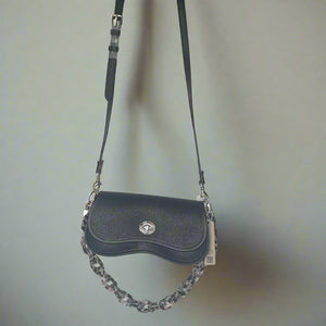 Black leather handbag with a chain detail on a light gray background