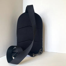 Load image into Gallery viewer, Black sling bag with a textured back on a white background
