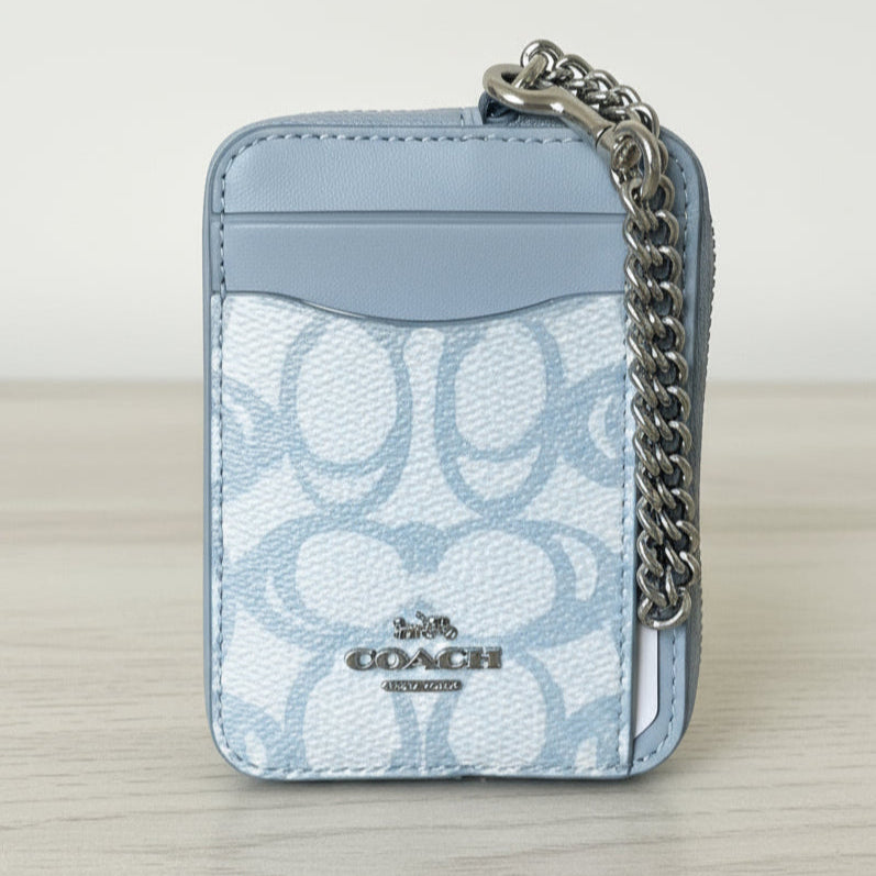 Light blue Coach wallet with chain detail on a white background