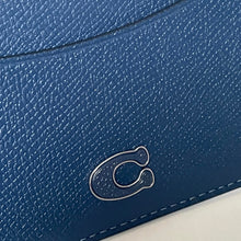 Load image into Gallery viewer, Close-up of a blue textured wallet with a brand logo on a white background