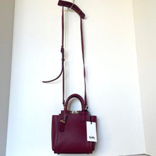 Load image into Gallery viewer, Maroon handbag with a tag on a white background