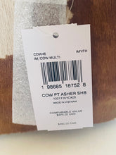 Load image into Gallery viewer, A white product tag with a barcode attached to a brown and white patterned item, showing text including 'CDW46', 'IM/COW MULTI', and 'COW PT ASHER SHB'.