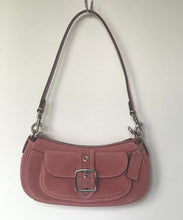 Load image into Gallery viewer, A dusty rose faux-leather shoulder bag with a silver buckle detail and a dark brown strap, hanging from a hook against a plain off-white wall.